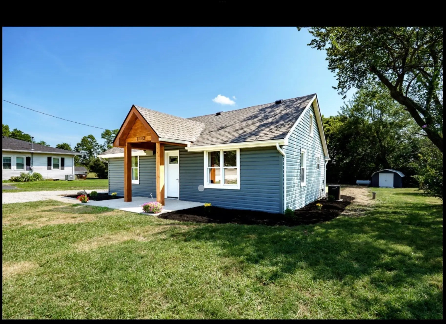 Fully renovated home with new siding, roof, and cedar porch by Green's Enterprises